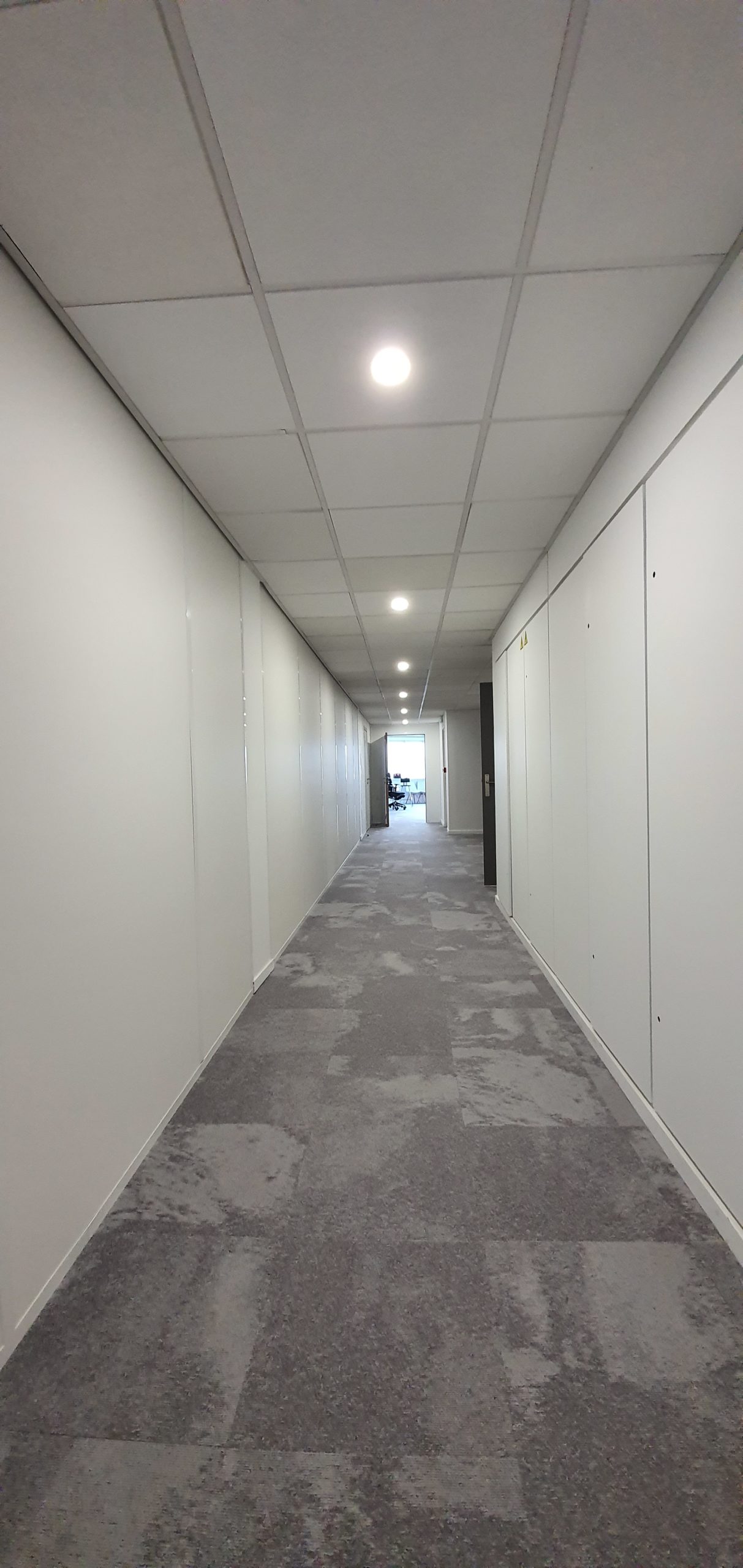 Couloir avec dalles de faux plafond bord droit à ossature et downlight